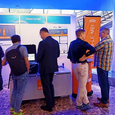 Infostand des Verbundprojekts KriKom-LK-MEI auf der Projektausstellung des BMFTR-Innovationsforums &raquo;Zivile Sicherheit&laquo; 2026